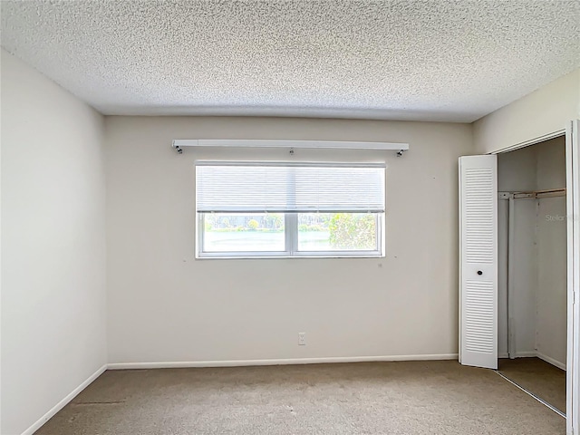 unfurnished bedroom with a textured ceiling and carpet