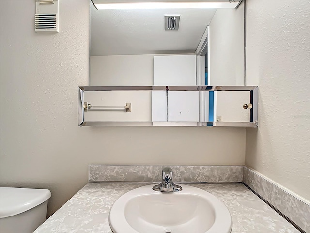 bathroom with toilet and vanity