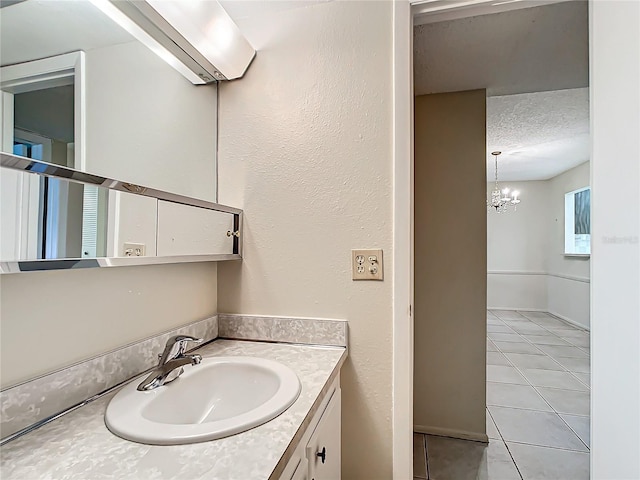 bathroom featuring a textured ceiling, tile patterned floors, vanity, and an inviting chandelier