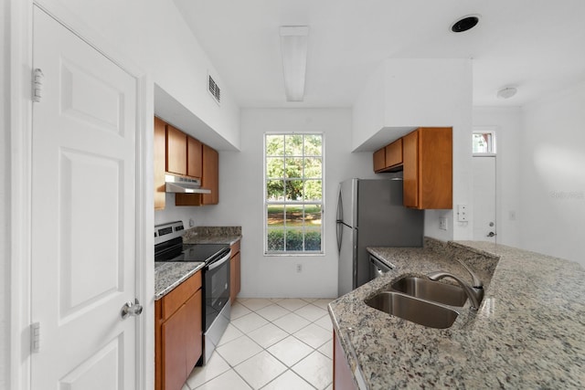 kitchen featuring light stone countertops, stainless steel appliances, sink, and light tile floors