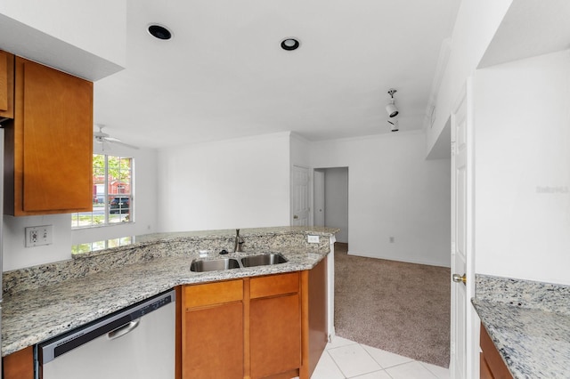 kitchen featuring light stone countertops, dishwasher, light tile flooring, track lighting, and sink