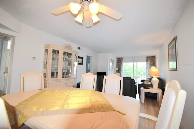 dining area with hardwood / wood-style flooring and ceiling fan