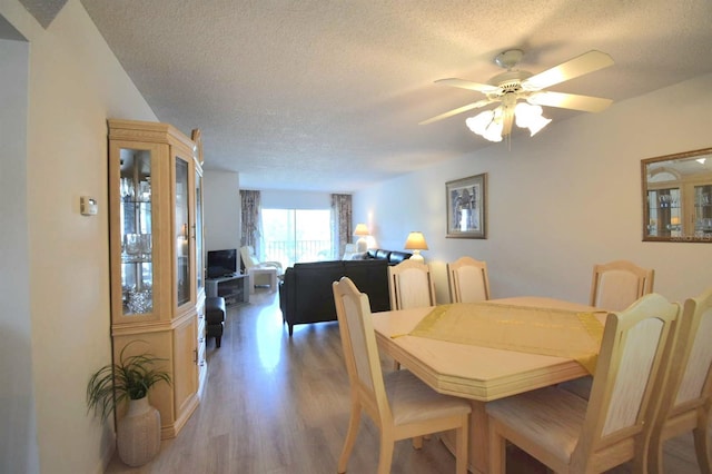 dining room with a textured ceiling, ceiling fan, and hardwood / wood-style floors