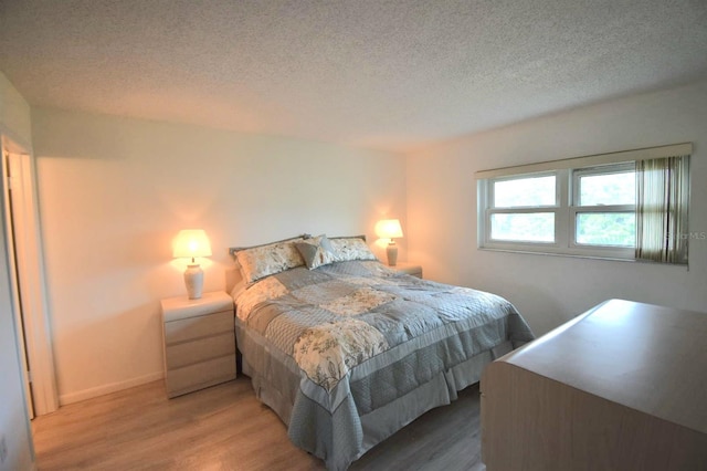 bedroom featuring a textured ceiling and wood-type flooring