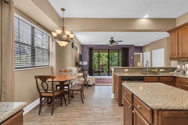 kitchen featuring hanging light fixtures, sink, ceiling fan with notable chandelier, and light wood-type flooring