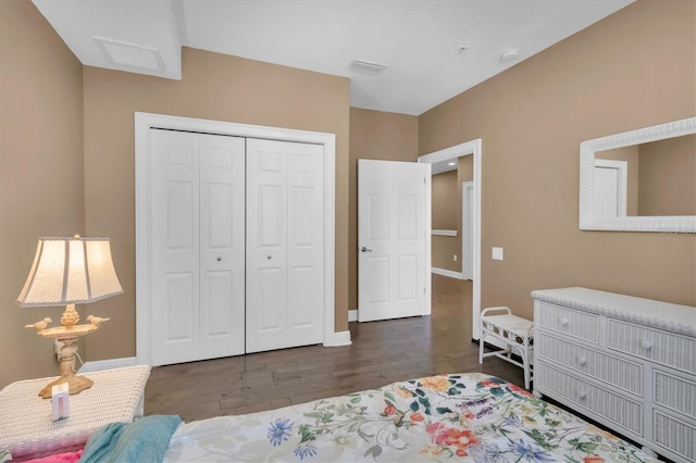 bedroom with dark wood-type flooring and a closet