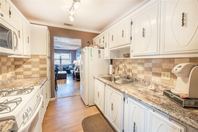 kitchen with light hardwood / wood-style floors, white appliances, track lighting, backsplash, and sink