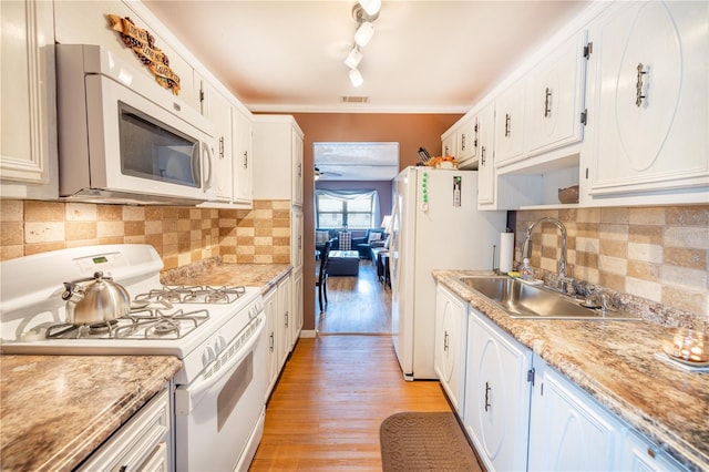 kitchen featuring light hardwood / wood-style flooring, white appliances, backsplash, rail lighting, and sink