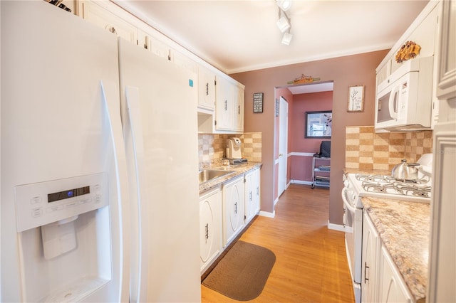 kitchen with light hardwood / wood-style flooring, backsplash, track lighting, white cabinets, and white appliances