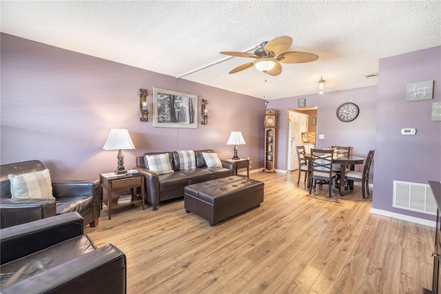 living room featuring a textured ceiling, ceiling fan, and hardwood / wood-style floors