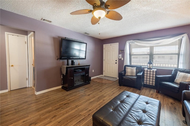 living room featuring a textured ceiling, dark hardwood / wood-style floors, and ceiling fan