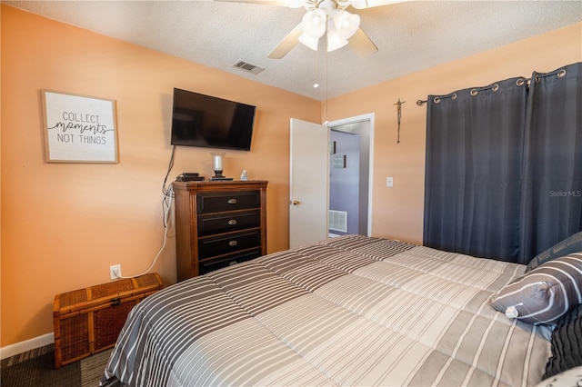 bedroom with ceiling fan and a textured ceiling