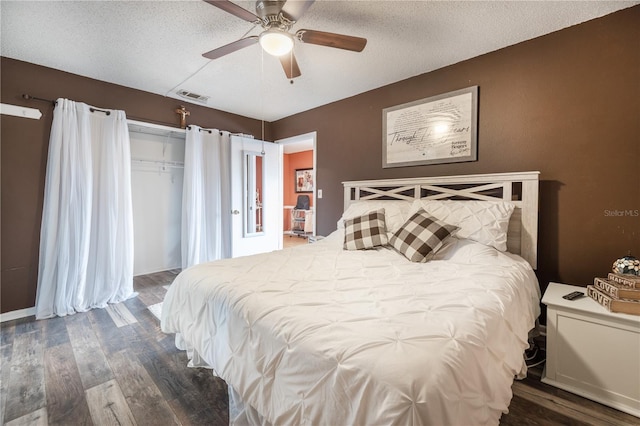 bedroom featuring ceiling fan, a textured ceiling, and dark wood-type flooring