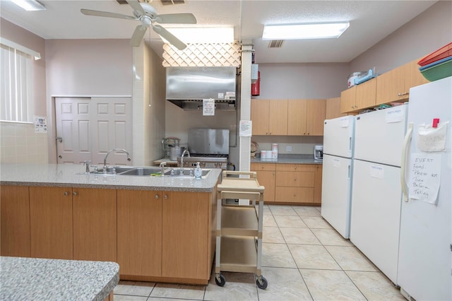 kitchen with white refrigerator, ceiling fan, light tile floors, and kitchen peninsula