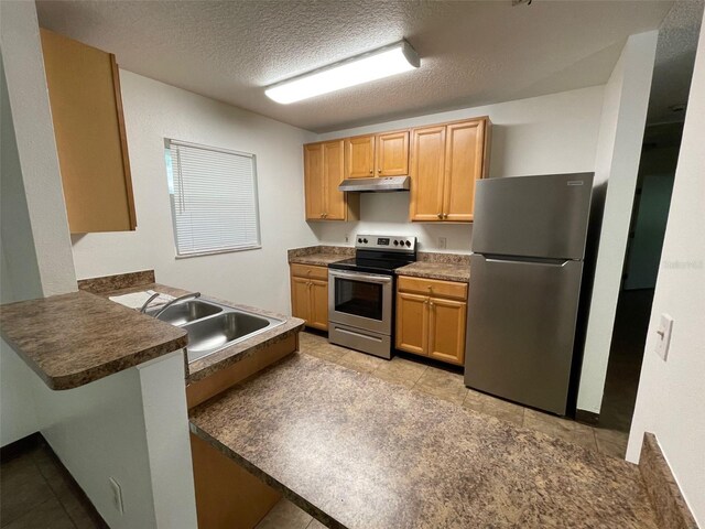 kitchen featuring kitchen peninsula, stainless steel appliances, a textured ceiling, light tile floors, and sink