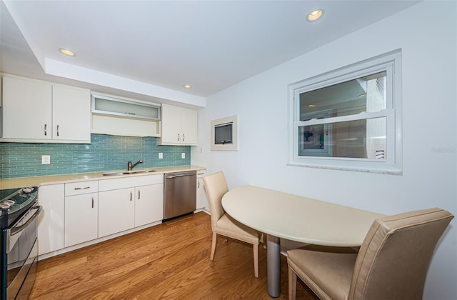 kitchen featuring light hardwood / wood-style floors, white cabinetry, stainless steel appliances, sink, and tasteful backsplash