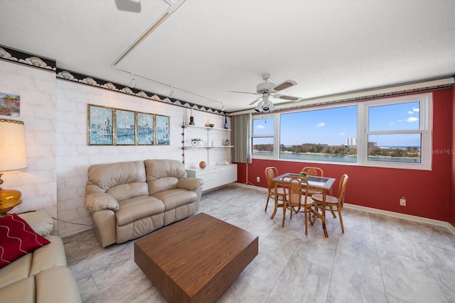 tiled living room featuring ceiling fan and a textured ceiling