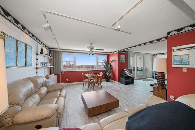 living room featuring ceiling fan, a textured ceiling, and rail lighting