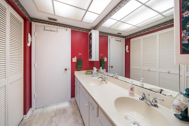 bathroom featuring dual sinks, tile floors, and large vanity