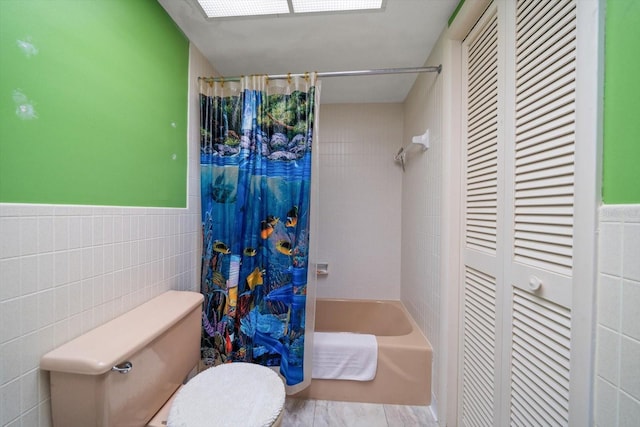 bathroom featuring shower / tub combo with curtain, toilet, and tile walls