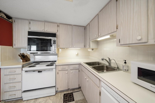 kitchen featuring sink, tasteful backsplash, white appliances, and light tile floors