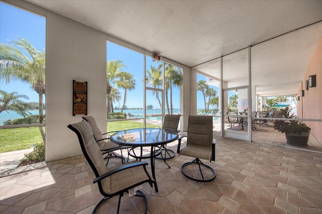 sunroom / solarium featuring a water view and plenty of natural light