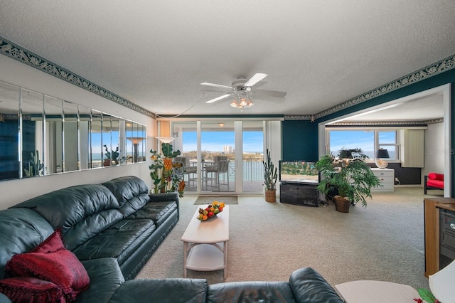 carpeted living room with ceiling fan and a textured ceiling