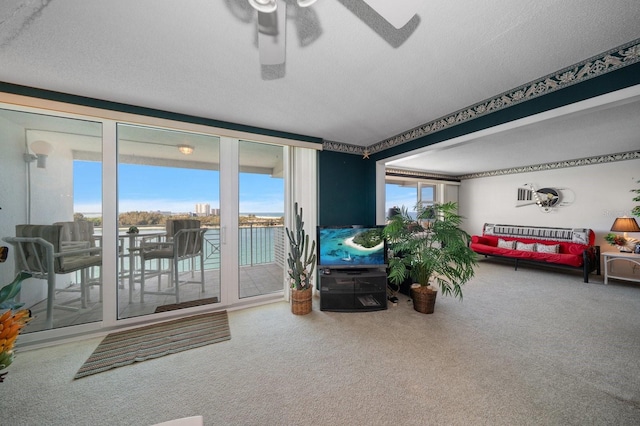 living room featuring carpet, ceiling fan, and a textured ceiling