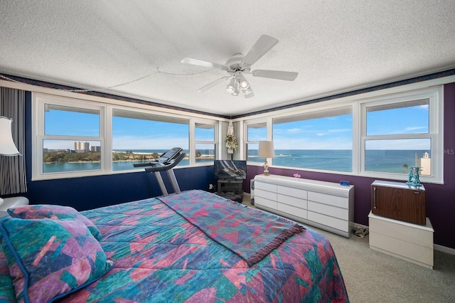 carpeted bedroom featuring ceiling fan, a textured ceiling, radiator heating unit, and a water view