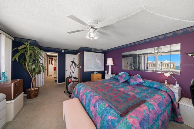 carpeted bedroom featuring ceiling fan and a textured ceiling