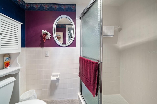 bathroom featuring a shower with shower door and toilet