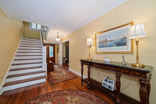 entrance foyer featuring crown molding, a textured ceiling, and dark wood-type flooring