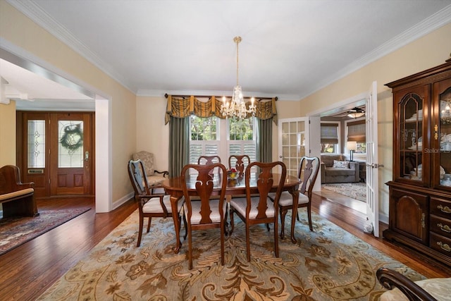 dining room with dark hardwood / wood-style flooring, ceiling fan with notable chandelier, and crown molding