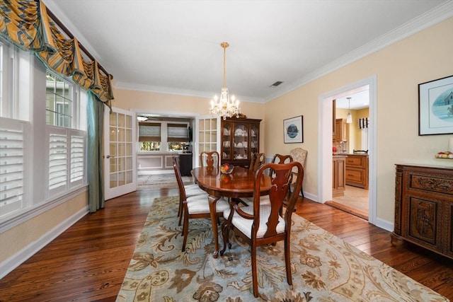 dining room with a chandelier, crown molding, and hardwood / wood-style floors