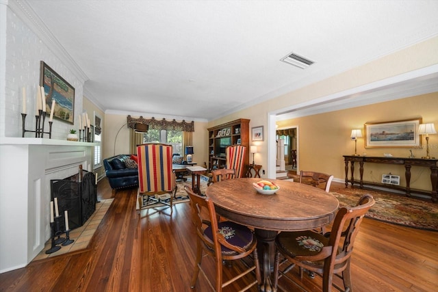 dining area featuring ornamental molding and dark wood-type flooring