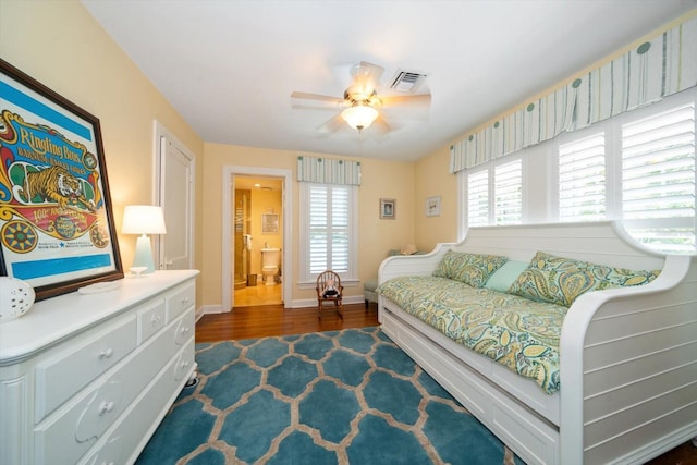 bedroom with ceiling fan, connected bathroom, and dark wood-type flooring