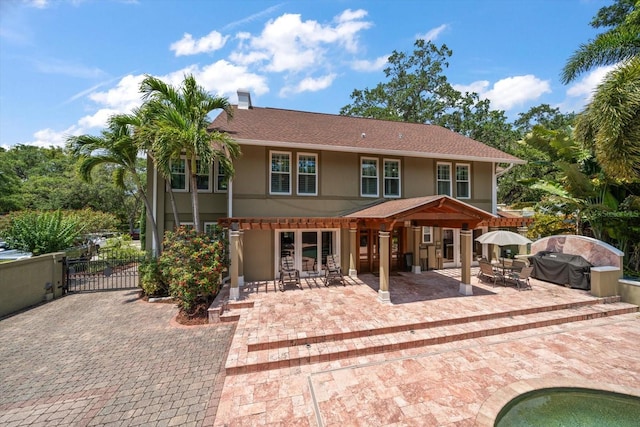 rear view of property with a pool and a patio