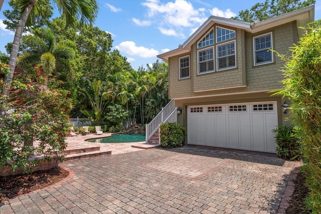 exterior space featuring a garage and a fenced in pool