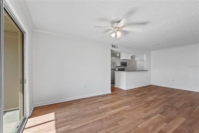 unfurnished living room with ceiling fan, ornamental molding, a textured ceiling, and light wood-type flooring