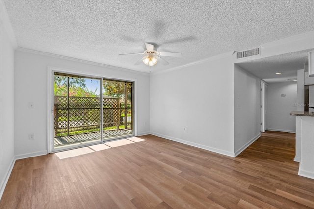 spare room featuring ceiling fan, hardwood / wood-style floors, crown molding, and a textured ceiling