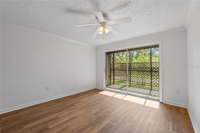 empty room with ceiling fan, hardwood / wood-style floors, a textured ceiling, and ornamental molding