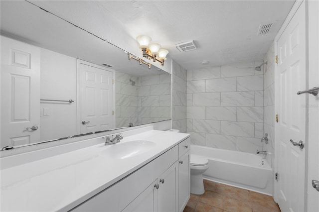 full bathroom with tile patterned floors, a textured ceiling, toilet, vanity, and tiled shower / bath