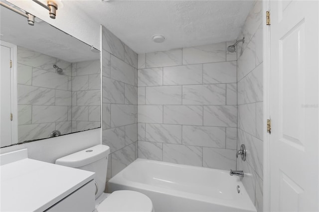 full bathroom with vanity, toilet, a textured ceiling, and tiled shower / bath