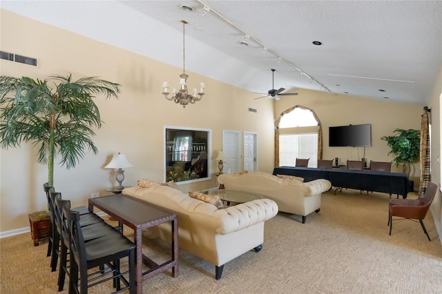 living room featuring ceiling fan with notable chandelier, track lighting, and vaulted ceiling