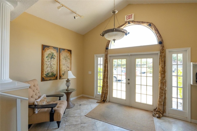 entryway with track lighting, lofted ceiling, a textured ceiling, and french doors