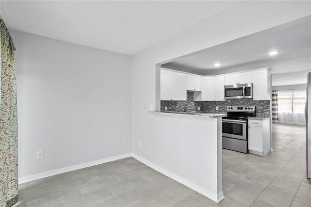 kitchen with light stone countertops, stainless steel appliances, backsplash, light tile floors, and white cabinets