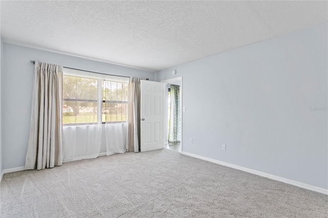 carpeted spare room featuring a textured ceiling