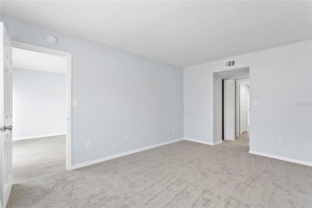 spare room with carpet flooring and a textured ceiling