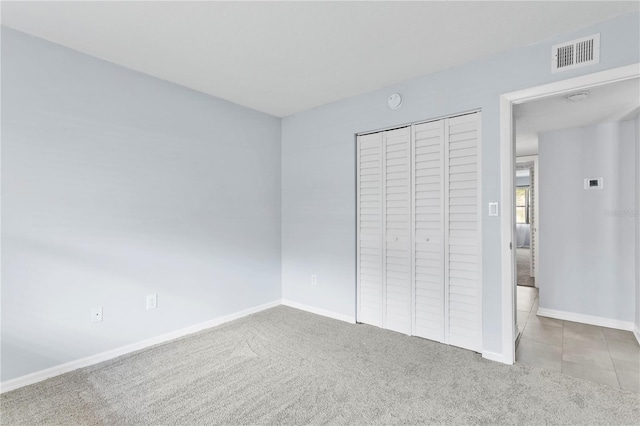 unfurnished bedroom with tile flooring and a closet