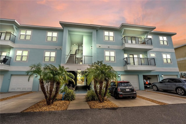 view of property featuring a garage and a balcony